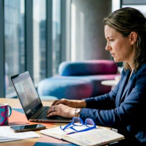 Zakenvrouw aan het werk op haar laptop in de SharePoint-omgeving van het bedrijf.