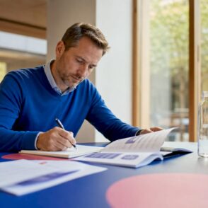 Een IT-manager zit aan zijn bureau en bekijkt de trainingsmaterialen zorgvuldig.