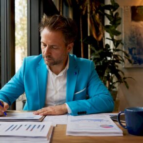 Een IT-consultant bekijkt in zijn kantoor verschillende vergelijkingsschema’s om een weloverwogen keuze te maken.