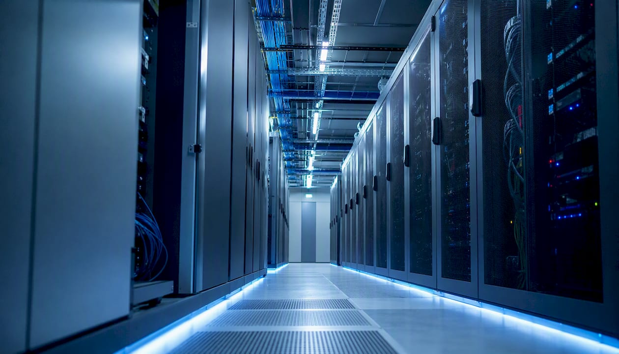 Een gangpad vol serverracks in een modern datacenter voor cloudopslag.